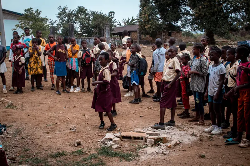 Schoolchildren gathered in a schoolyard.